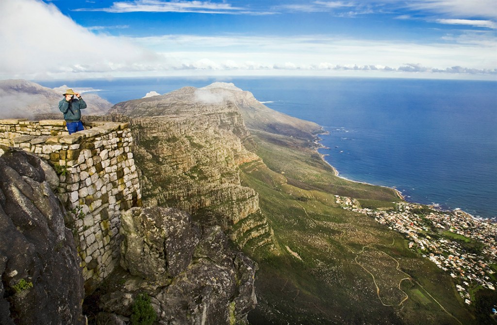 A hiker enjoys the views from the top of Table Mountain with Cape Town far below.