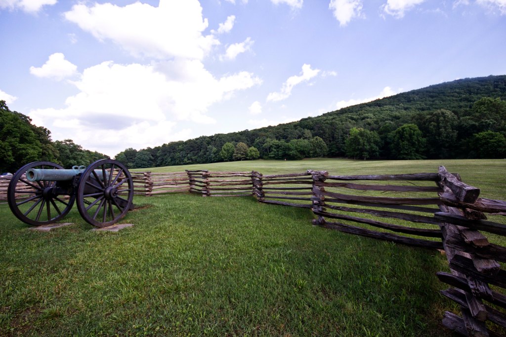 Green grass fields plus a canon in the foreground.