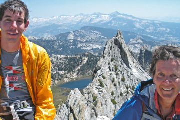 Diedre Wolownick sits on the summit of Matthes Crest with her son, Alex Honnold. In the background the sharp ridgeline of Matthes Crest rises up out of the landscape.