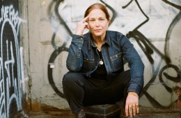 Karen Rinaldi in front of a graffiti wall.