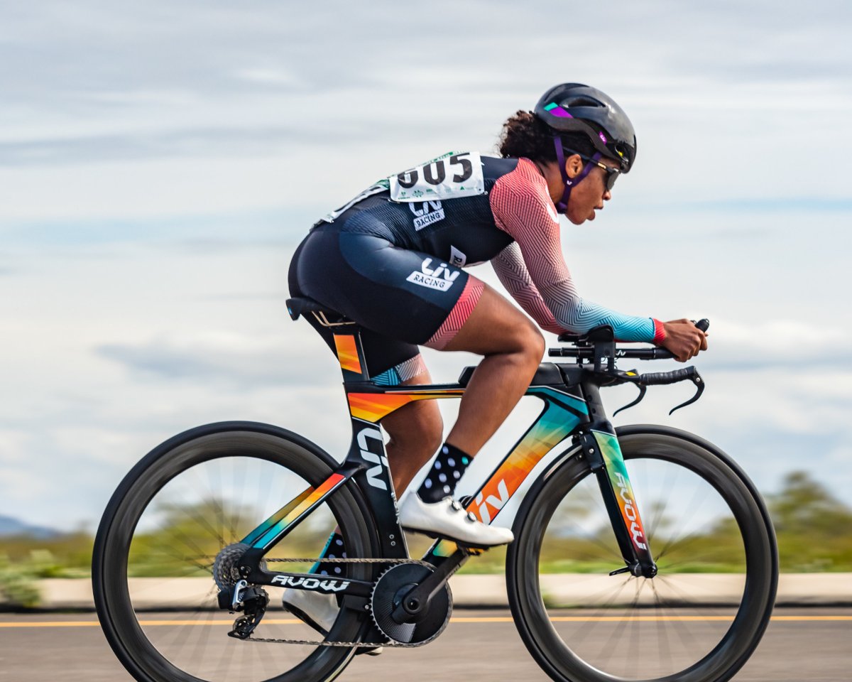 Ayesha McGowan pedals on her road bike while the landscape blurs in the background