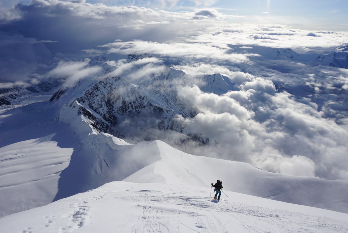 A person skis down a slope from the top of Denali in Alaska