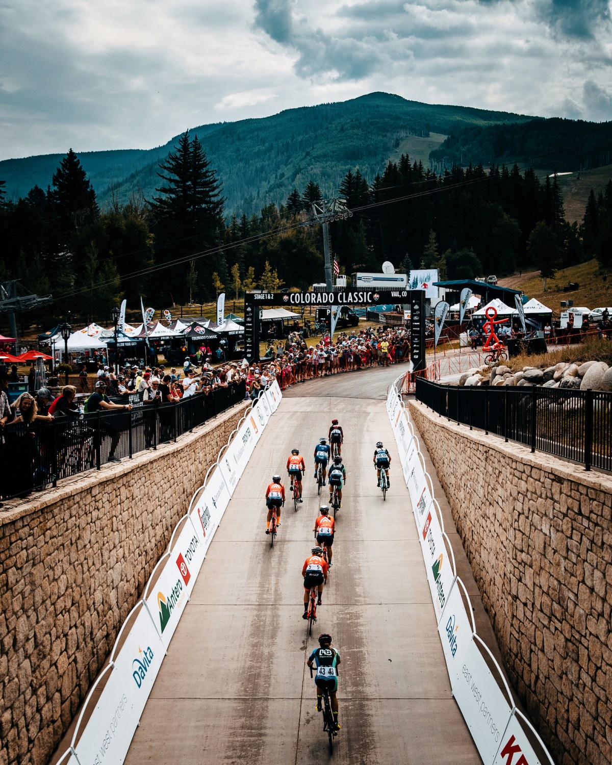 Cyclists in the Colorado Classic ride a road toward the mountains