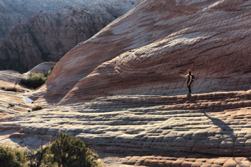 A woman takes a selfie surrounded by a beautiful landscape