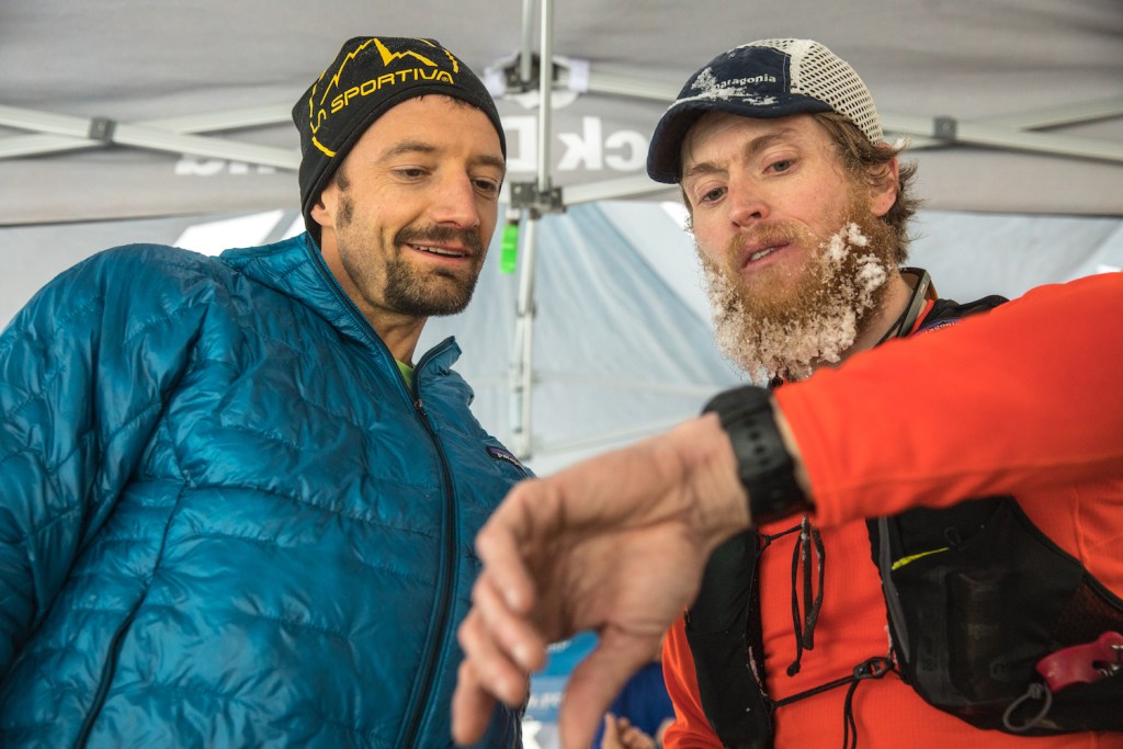 Jared Campbell checks the time with another runner at his Utah running event for clean air.