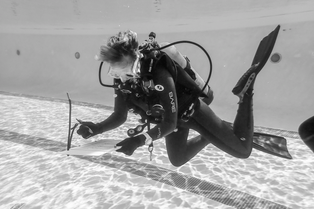 A diving practices collecting data in a swimming pool