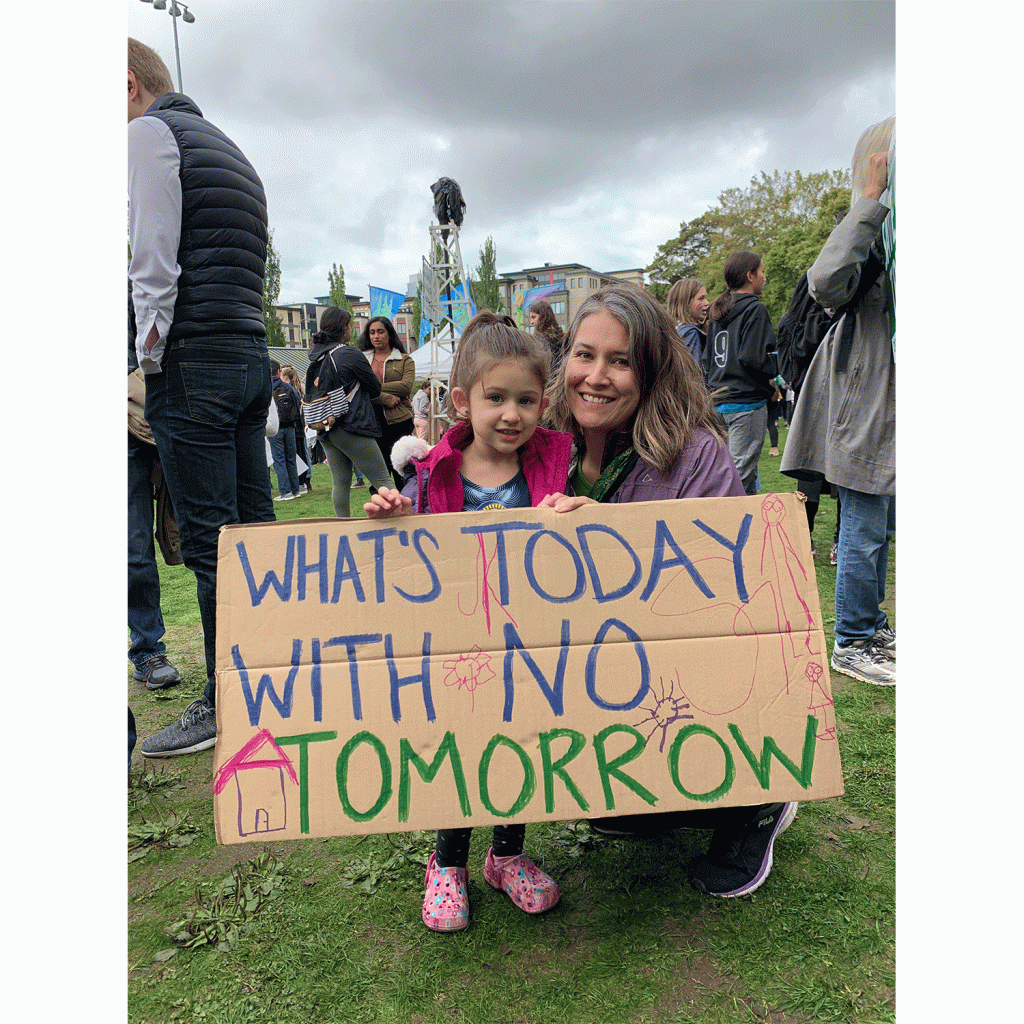 A mother and daughter holding a sign in Cal Anderson Park