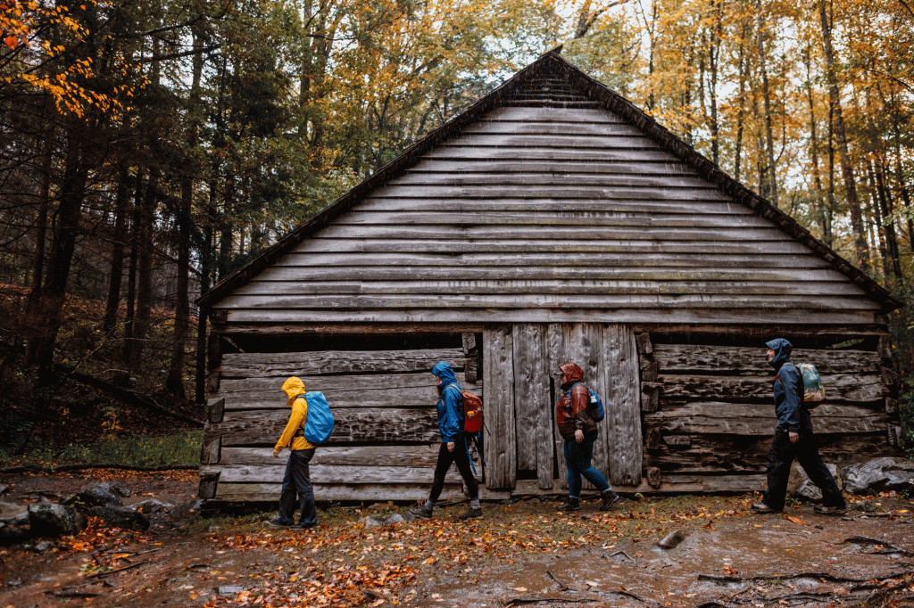 Hikers walk by a wooden structure
