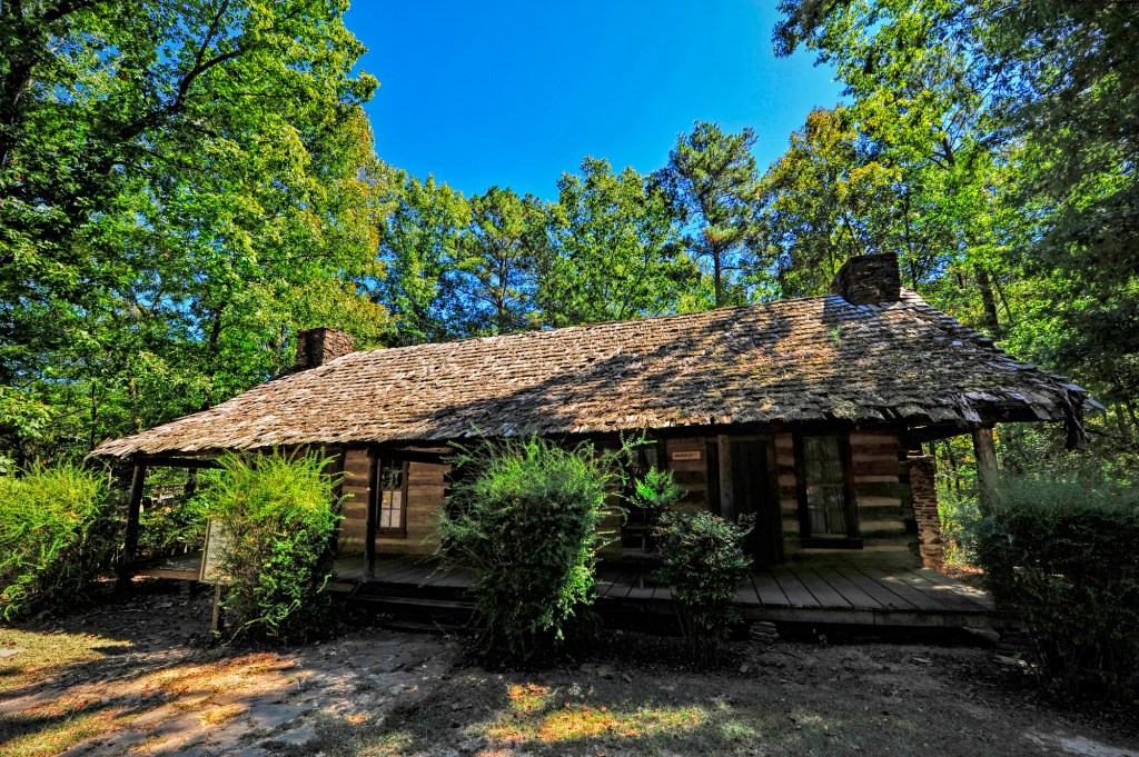 A historic building with trees and shrubs.