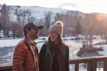 Two people looking at each other fondly in the outdoors