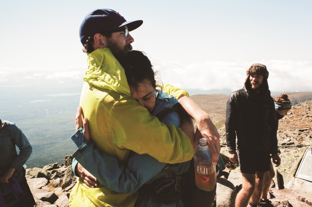 Two thru-hikers hug at the end of their hike.