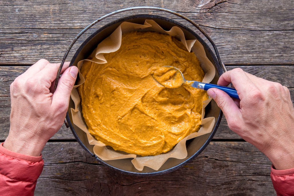 Spreading pumpkin coffee cake batter into dutch oven