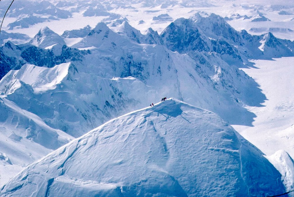 An aerial shot of a white, snowcapped peak