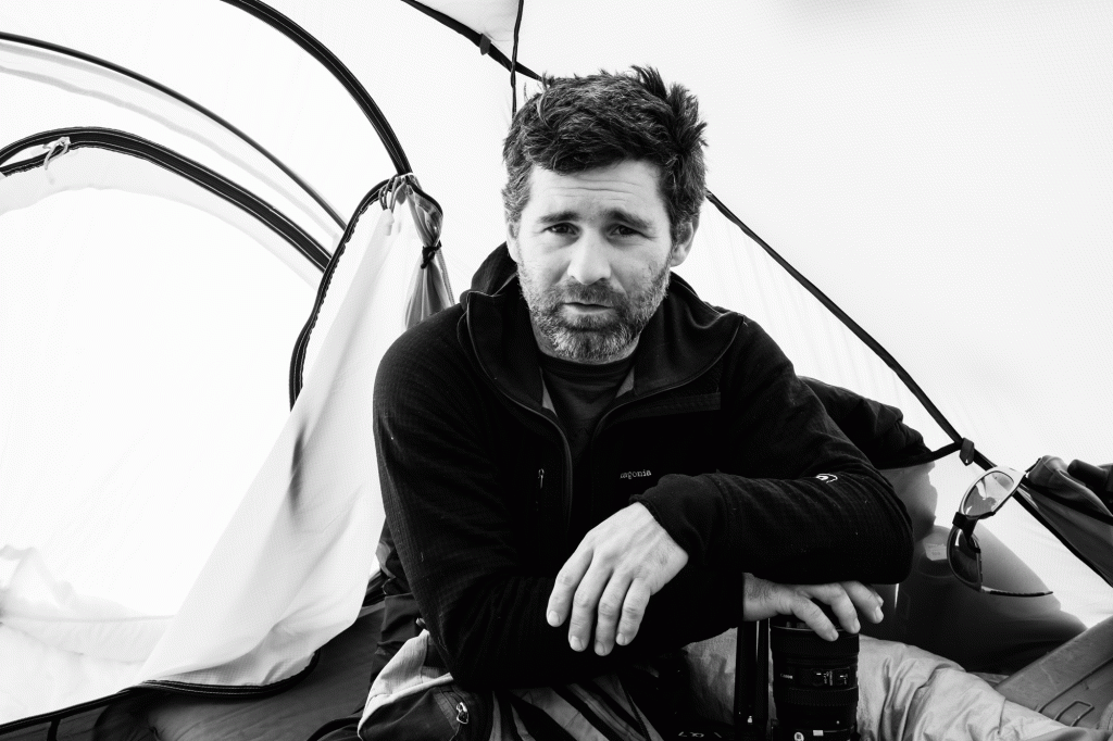 A filmmaker pauses for a photo inside a tent