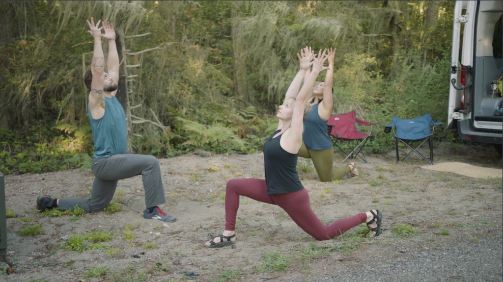 Corepower yoga instructors hold crescent moon half split pose