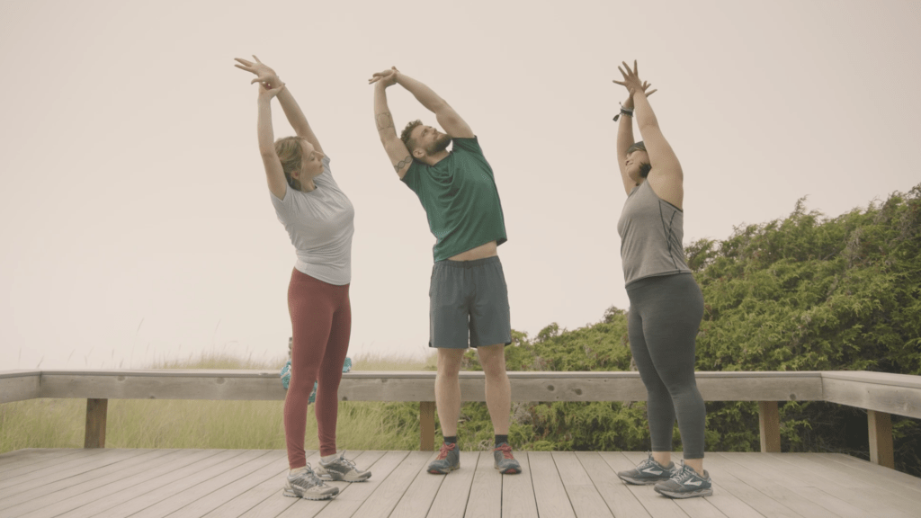 Corepower yoga instructors hold mountain pose side stretch