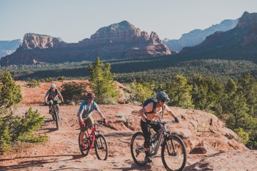 Three people ride mountain bikes in Sedona.