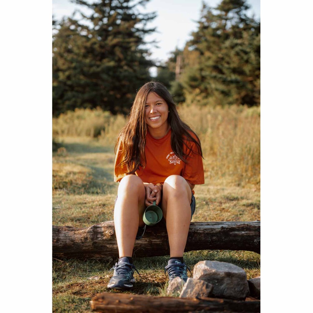 A young woman poses for the camera after a hard day's work in the backcountry