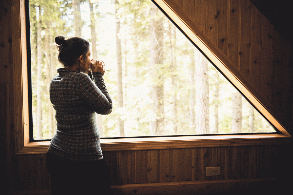 A woman sips a cup of coffee while staring into the middle distance
