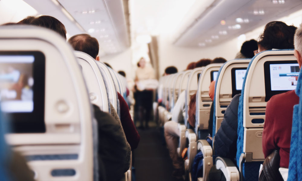 Looking down the aisle of a full airline flight.