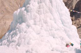 Children approach an ice stupa in the Himalaya