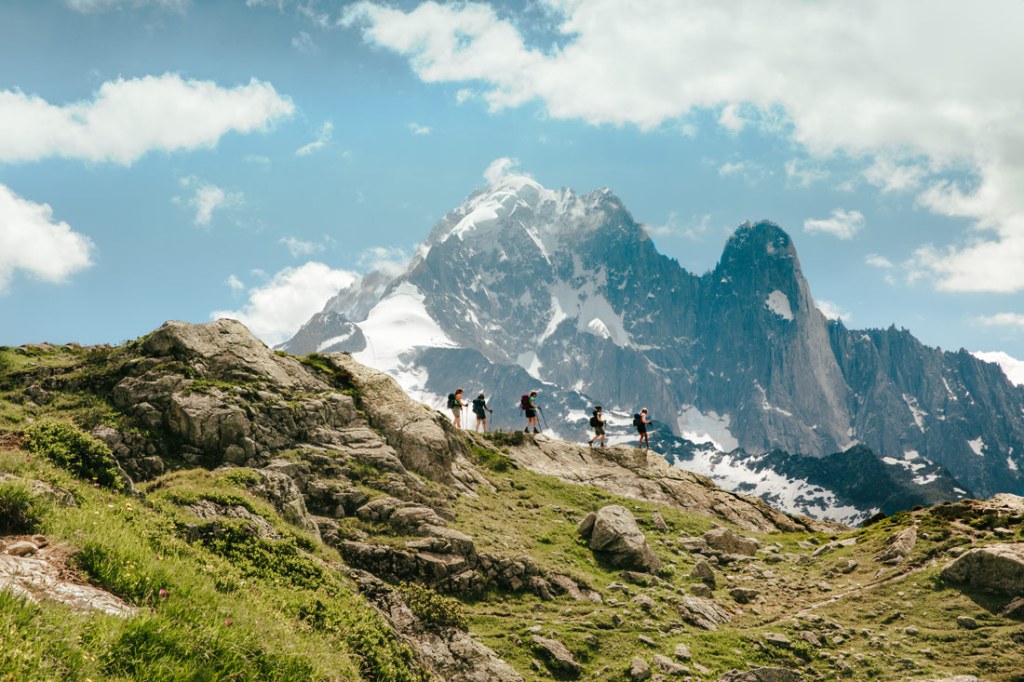 Hikers traverse a ridgeline in the Alps. 