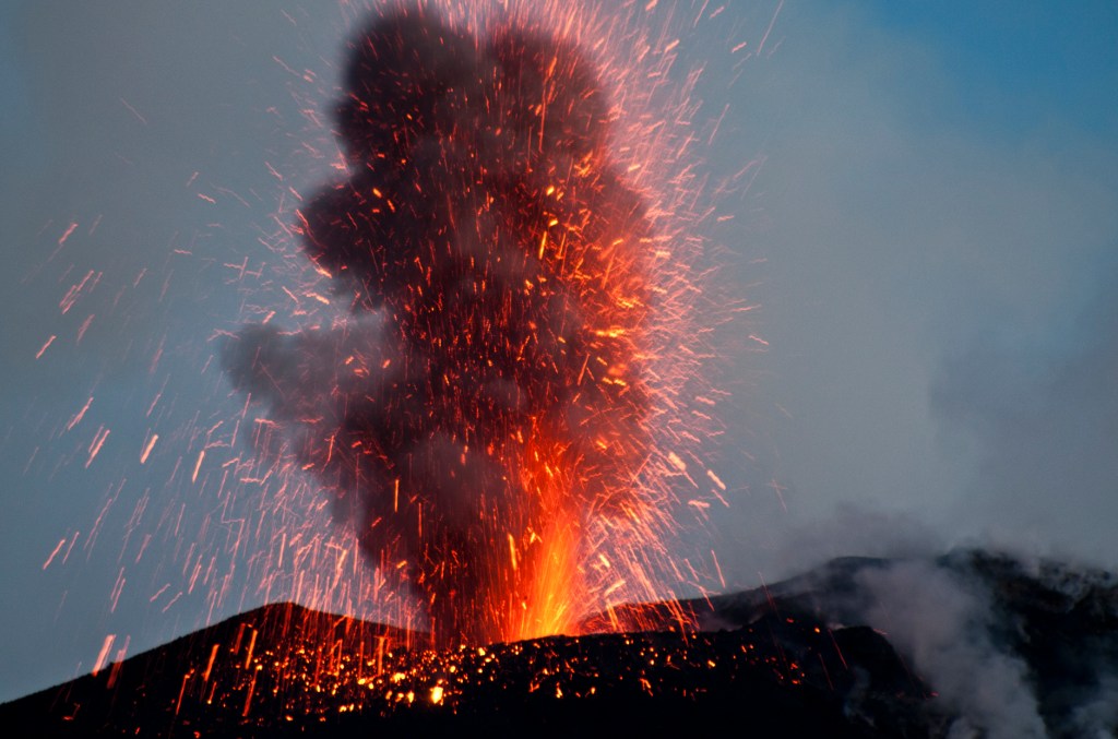 Lava spews into the evening sky.