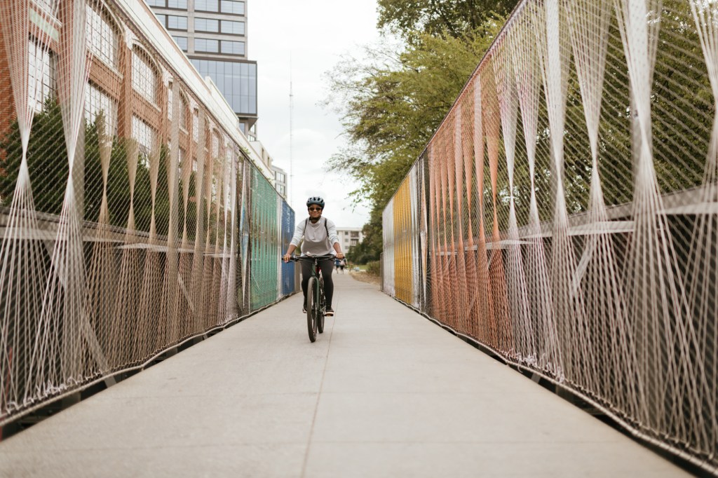 A biker rides along a pedestrian bridge