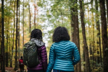 Two female hikers looking into the woods.