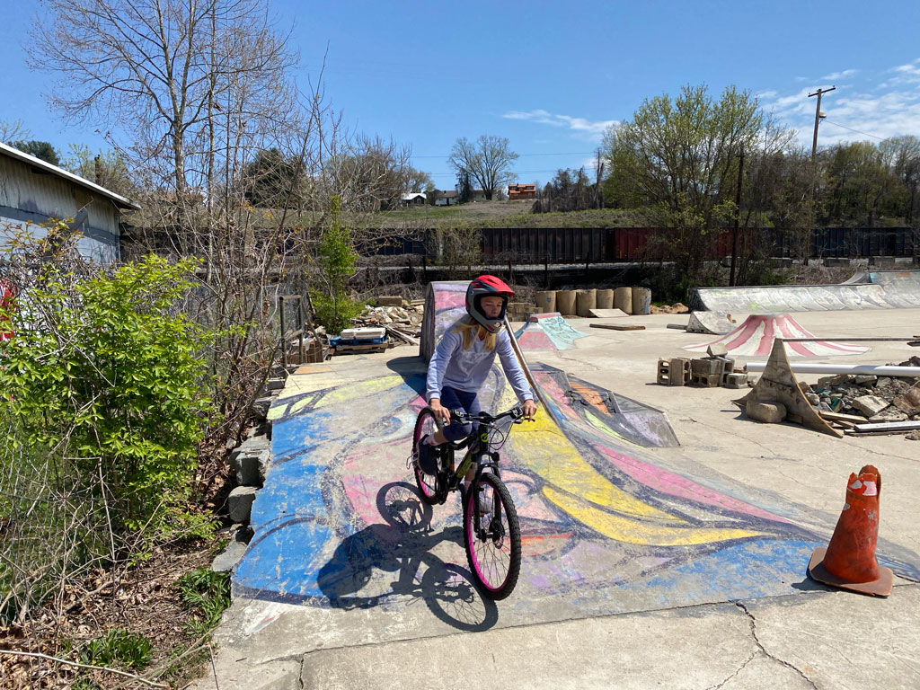 Addie riding a bike in a skate park