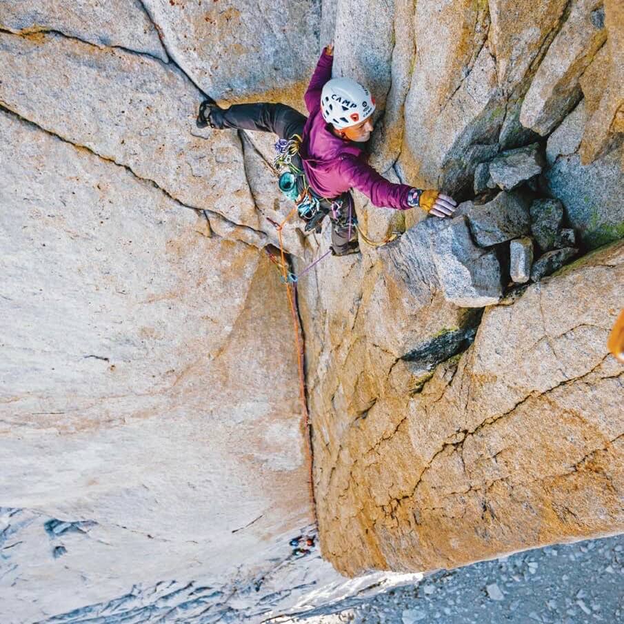 A woman rock climbs.