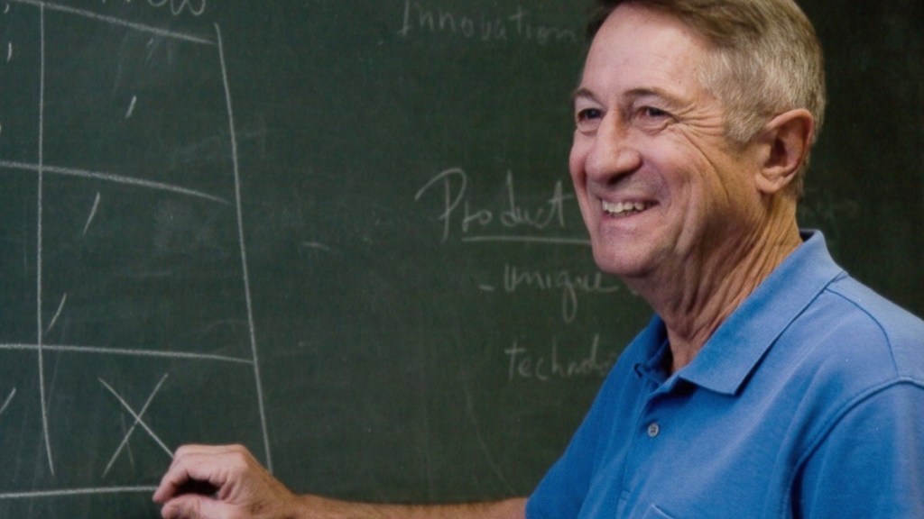 Man writing on chalkboard.