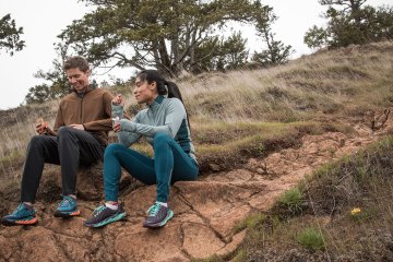 Runners sitting on a trail eating snacks