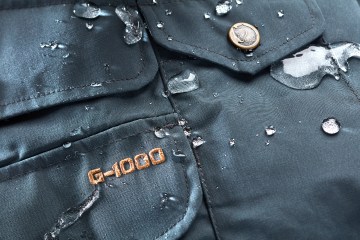 An up close image of a Fjallraven jacket with water beading on it.