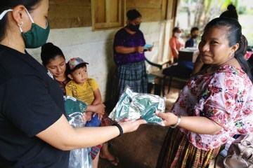 A woman distributes masks to aid with COVID-19 relief.
