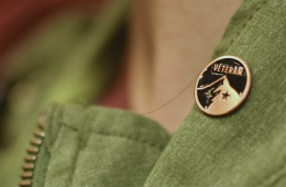 An REI store employee wears a small Veteran pin on their vest