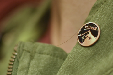 An REI store employee wears a small Veteran pin on their vest