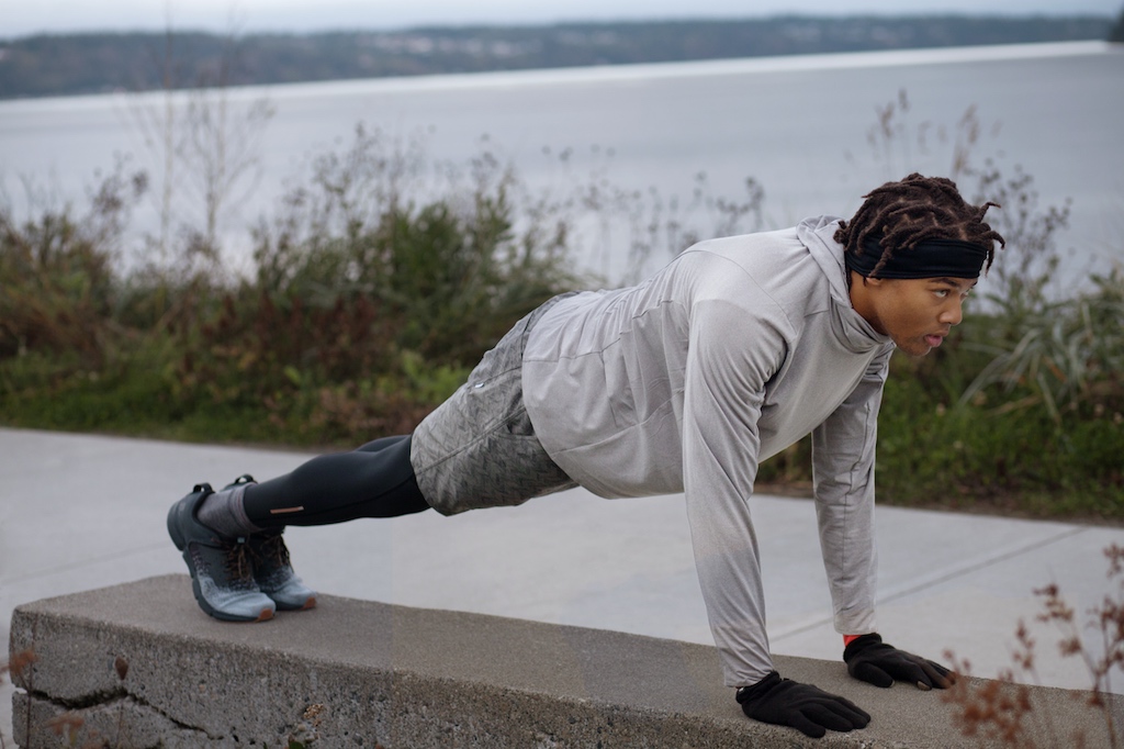 Man doing pushup on park bench outside