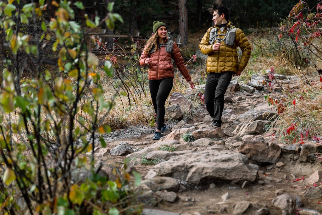 Two people walking on a hill.