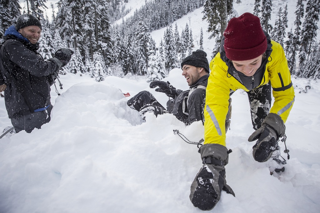 Three people playing in snow.