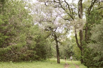 Two runners wind their way through a community park in Austin