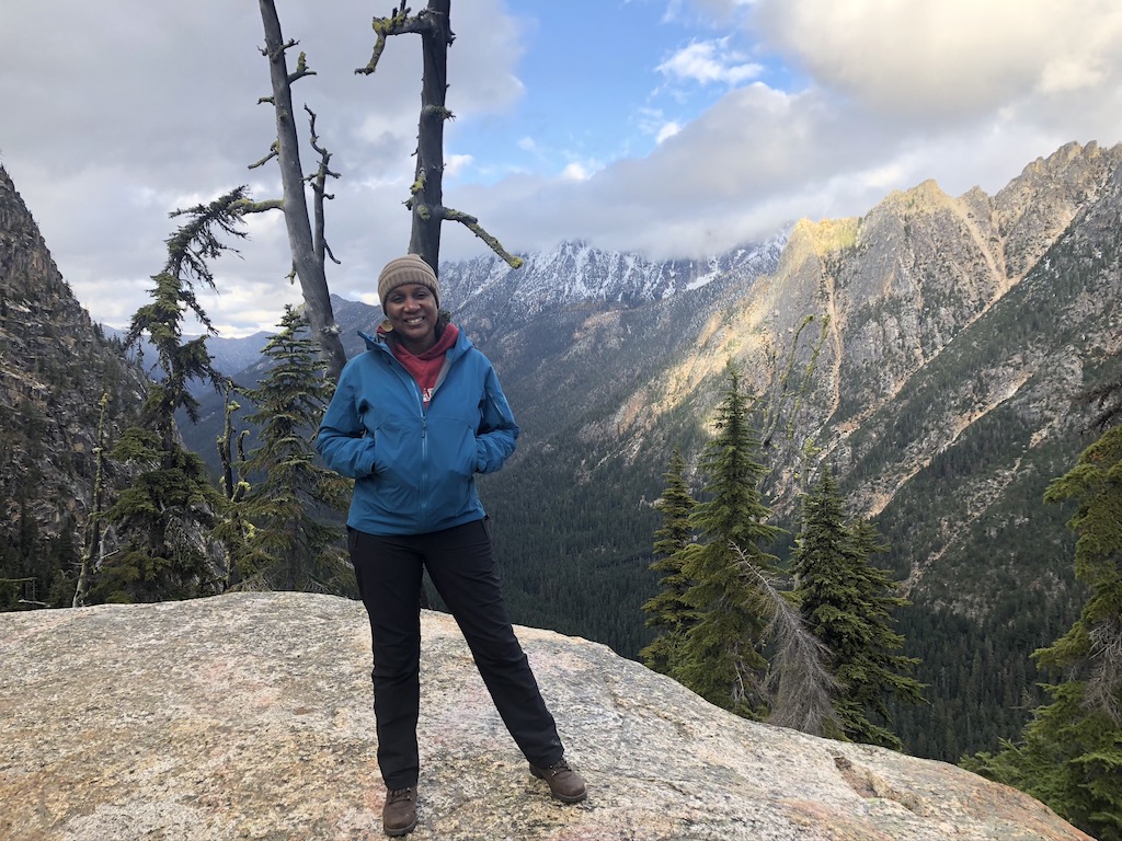 Woman standing at a scenic mountain lookout