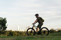 Person riding bike with city in background.