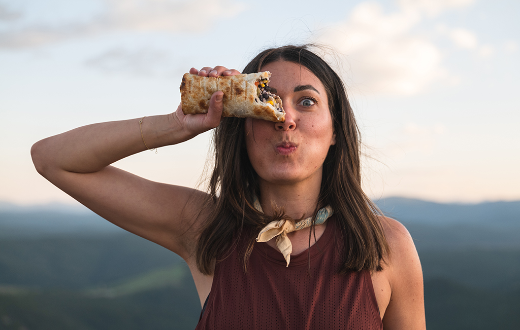 A hiker enjoys a trailside burrito.