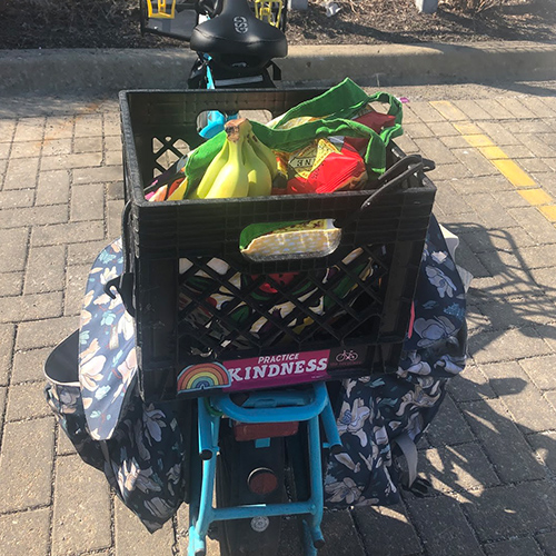 Photo of groceries in a milk crate on back of bike.