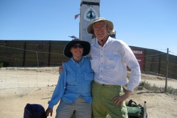 Frodo and Scout (aka: Barney and Sandy Mann) smile at the camera with the arms around each other at the start of the PCT.