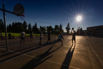 A group of friends play basketball on the playground of Eckstein Middle School