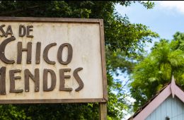 A photo of a blue house with a sign in the foreground that says Casa de Chico Mendes.