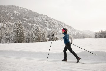 a cross-country skier skates on a groomed track