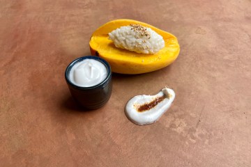 Photo of a sliced mango and bowl of coconut milk.